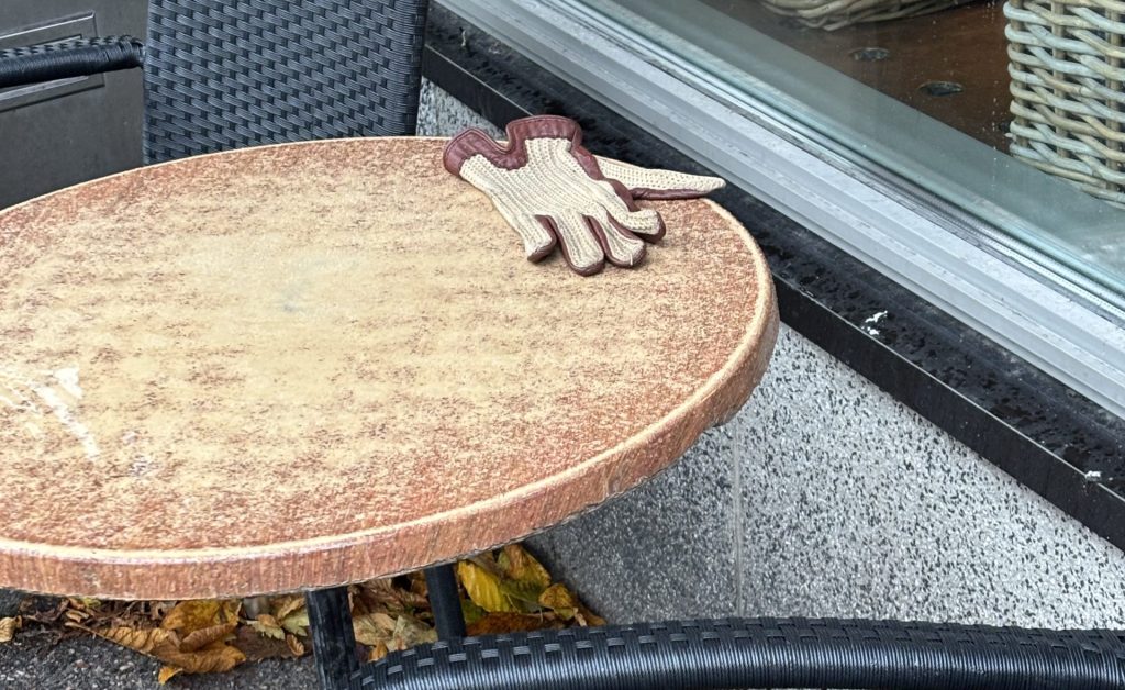 Yksinäinen hansikas pyöreällä pöydällä